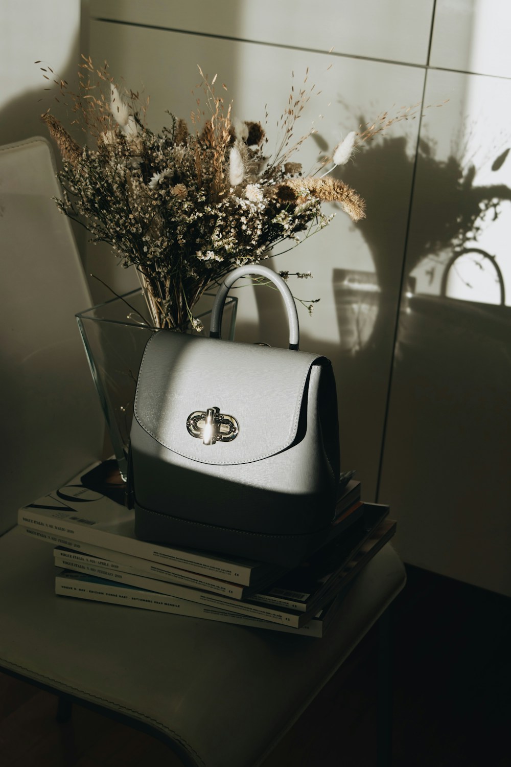 Grey leather handbag on books — sample listing photo, not verified inventory
