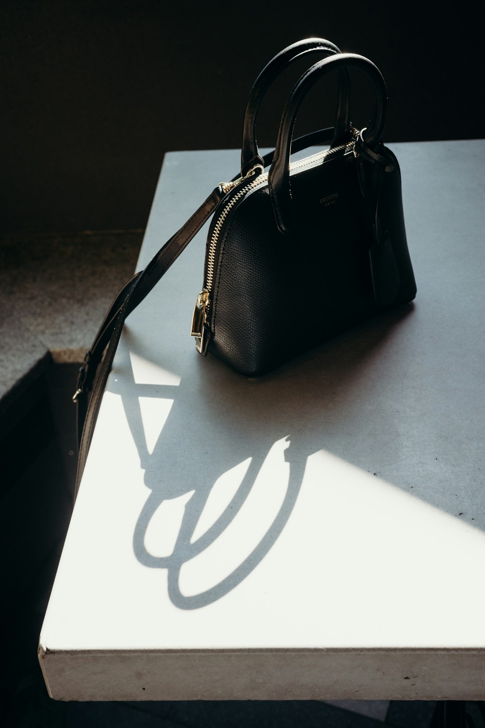 Black handbag on a light surface — sample listing photo, not verified inventory